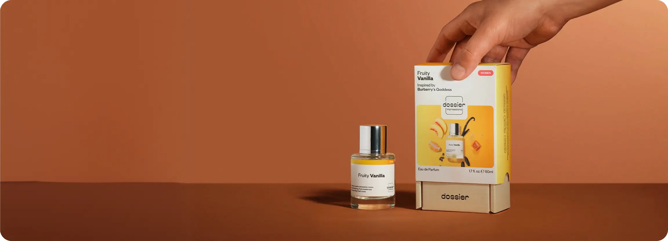 Dossier Fruity Vanilla perfume displayed beside its packaging as a hand places the box on a stand.